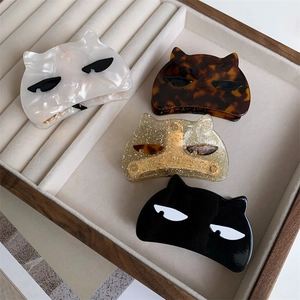 Cute semicircular acetate cat hair claws in four colors on a velvet tray