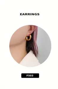 Macro detail of chunky gold-plated C-shaped earrings with a smooth polished finish
