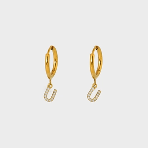 Close-up of gold-plated hoop earrings featuring a U-shaped pendant with pavé cubic zirconia