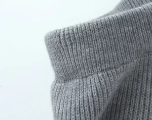 Detail shot of light gray knit fabric showing the ribbed cuff texture and soft fuzzy material