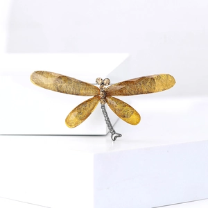 Detailed view of dragonfly brooch wings featuring amber resin with gold foil and crystals