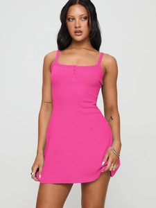 Gros plan sur la texture côtelée et les boutons d'une mini-robe moulante rose fuchsia