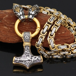 Detail of Viking Mjolnir pendant with gold wolf head design on Byzantine chain necklace