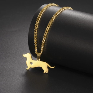 Detailed close-up of golden dachshund dog pendant with heart cutout on steel necklace