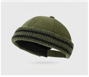 Detail der armygrünen Dockermütze mit gestreiftem Strickrand und Verstellband