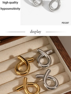 Detail of fish-shaped earrings in gold and silver finish inside a velvet jewelry box