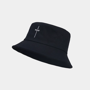 Close-up of white PEACE embroidery and fine cotton canvas texture on a black bucket hat