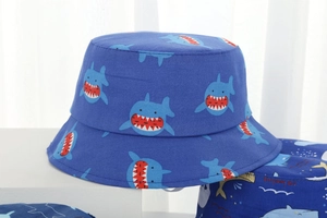 Detailed view of the breathable blue cotton bucket hat with cute cartoon shark print