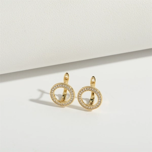 Macro shot of vintage gold pentagram earrings with white crystal inlay on leather