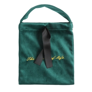 Elegant green velvet drawstring gift bag with black ribbon handle and gold embroidery