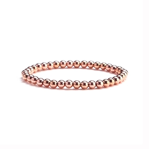 Detailed view of polished rose gold bead bracelet featuring high gloss metallic finish