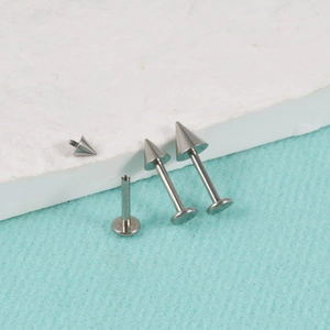 Detailed macro view of G23 titanium silver horseshoe lip rings with pointed spike studs
