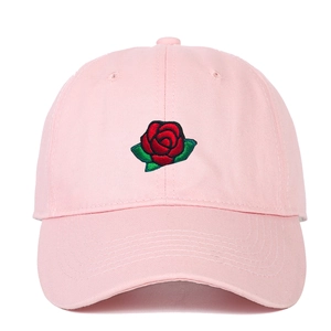Pink cotton baseball cap with red rose floral embroidery on a white background