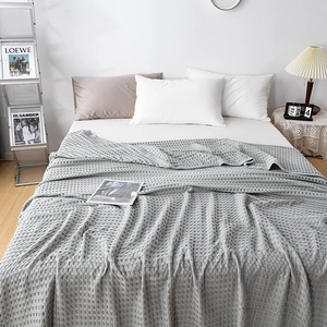 Detail of grey waffle weave cotton blanket showing soft texture and premium knit pattern