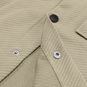 Macro shot of khaki jacquard knit shirt jacket with button and metallic snap details