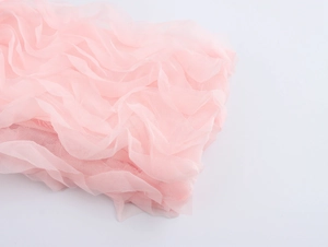 Détail du tissu en maille 3D rose avec des plis doux et une texture de tulle semi-transparent
