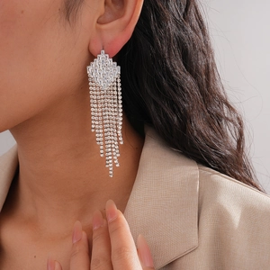 Close-up of sparkling silver zircon long tassel earrings worn with an elegant outfit