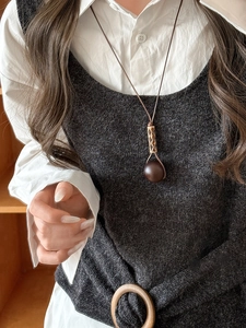 Close-up of vintage wood and resin geometric pendant on a brown cord necklace