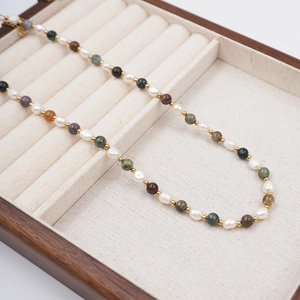 Colorful stone and freshwater pearl necklace on a premium wooden jewelry tray