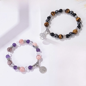Détail de bracelets en pierres naturelles avec pendentifs Arbre de Vie sur socles blancs