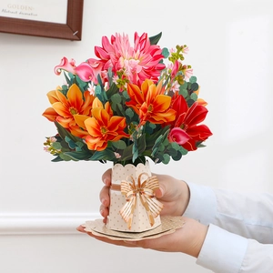 Detail of 3D pop-up flower bouquet card with colorful blooms and a gold bow on a spotted base