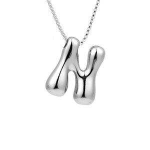 Detail of silver puffy bubble letter N pendant on a sleek stainless steel chain necklace