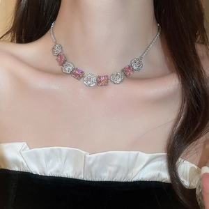 Close-up of silver necklace with pink square gemstones and zircon flower motifs on model