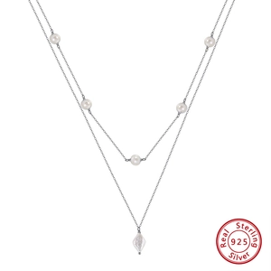 Detail of S925 sterling silver chain with white round pearls and unique baroque pearl pendant