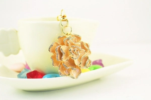 Close-up of golden rose keychain with pink enamel petals and sparkling rhinestones