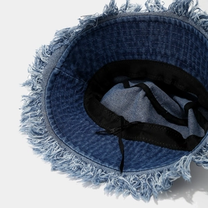 Denim bucket hat with frayed edges featuring a vintage wash and interior adjustment strap