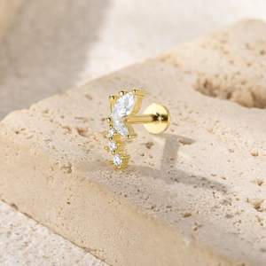Macro shot of gold S925 sterling silver butterfly stud with zircons on beige stone