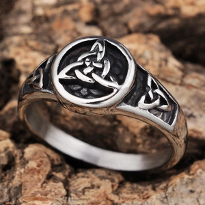 Vintage silver Viking rune ring with Celtic knot engraving on natural wood background