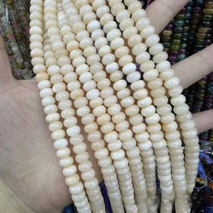 Macro shot of multiple strands of cream-colored abacus-shaped natural stone beads