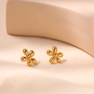Macro view of 18K gold plated flower earrings with intricate beaded edges and petal detail
