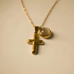 Golden double pendant necklace with a minimalist cross and round opal cat eye stone