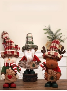 Detailed view of standing Christmas plush figures with burlap hats and festive sacks