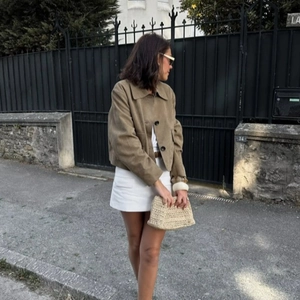 Women's brown suede short jacket with lapel collar shown in an outdoor street style