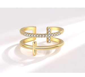 Close-up of golden double-layer cross ring with sparkling zircon stones in a detailed view