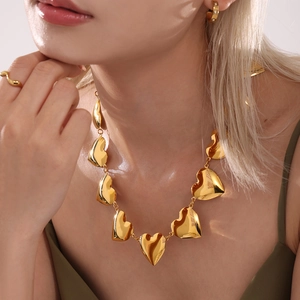 Elegante collar de eslabones de corazón dorado con conjunto de joyas a juego en una modelo