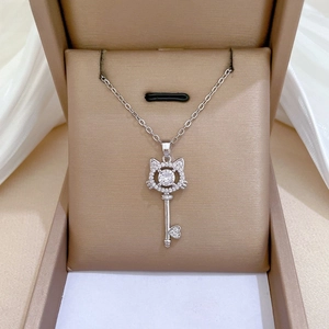 Detailed macro view of a silver cat key pendant with zircon stones in a jewelry box