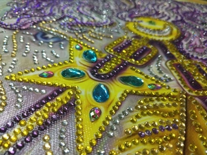 Macro detail of 5D DIY diamond painting with sparkling colorful resin rhinestones