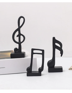 Close-up of minimalist matte black music note resin sculptures on rectangular bases