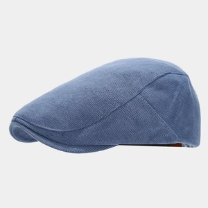 Detailed side view of a light blue knitted cotton newsboy cap with retro texture