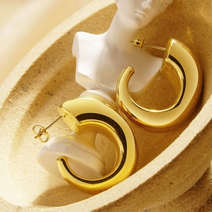 French vintage chunky gold C-shape hoop earrings in a minimalist aesthetic
