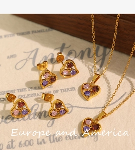 Detailed shot of gold heart jewelry set with red pink and purple zircon stones