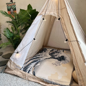 Bohemian style camping blanket with Great Wave print inside a cozy teepee tent setup