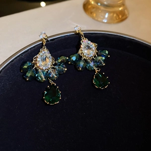 Macro shot of vintage style waterdrop earrings with green crystals and rhinestones