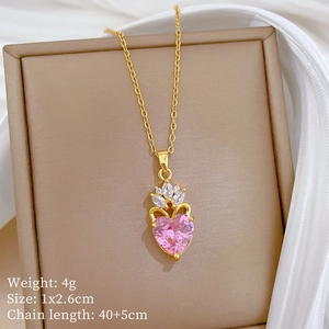 Close-up of pink heart pendant with crown design and crystals on a gold chain necklace