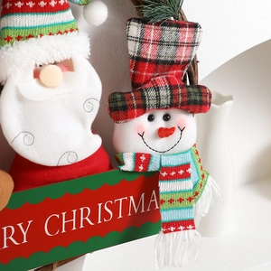 Christmas wreath with plush Santa and Snowman dolls featuring Merry Christmas sign