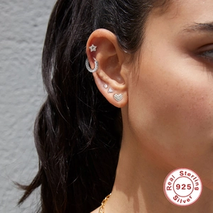 Close-up of S925 sterling silver ear studs and cuffs featuring star and heart shapes